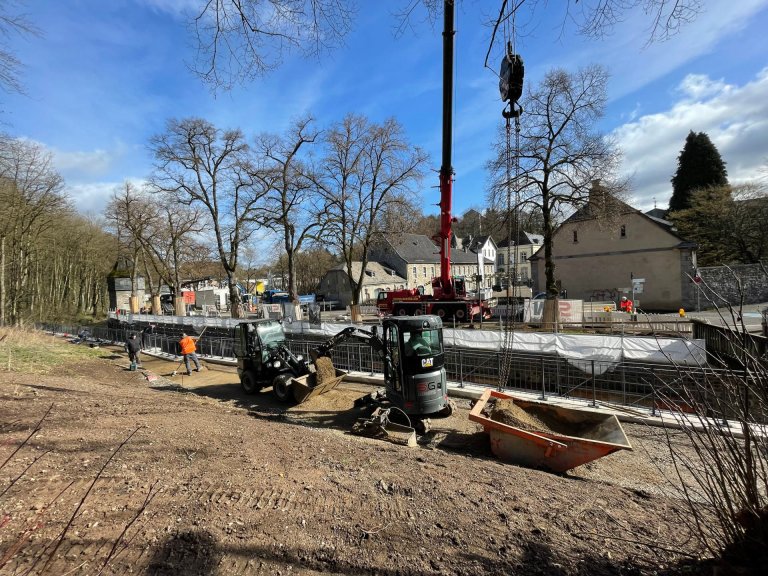 Baumaschinen stehen an der Ufermauer der Inde in Kornelimünster.