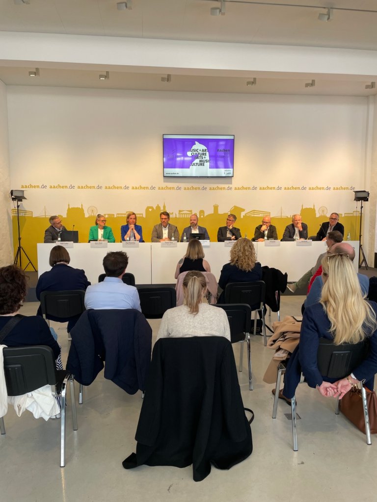 Menschen auf einem Podium sitzend