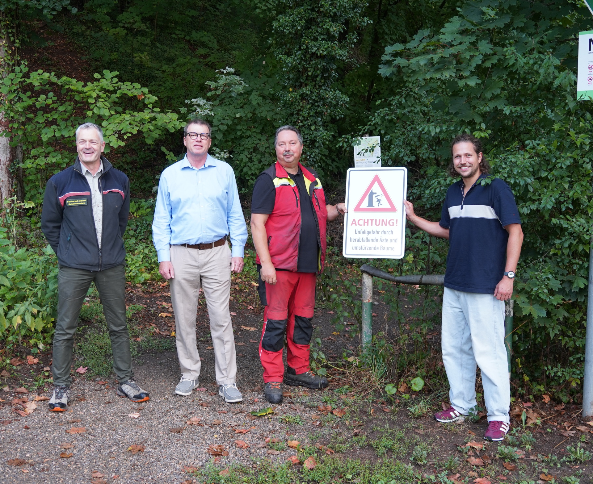 Vier Männer präsentieren ein Warnschild