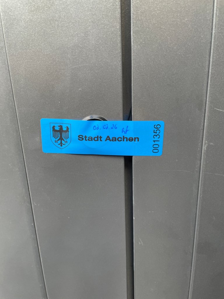 Ein städtisches Siegel klebt auf dem Schloss einer Türe.