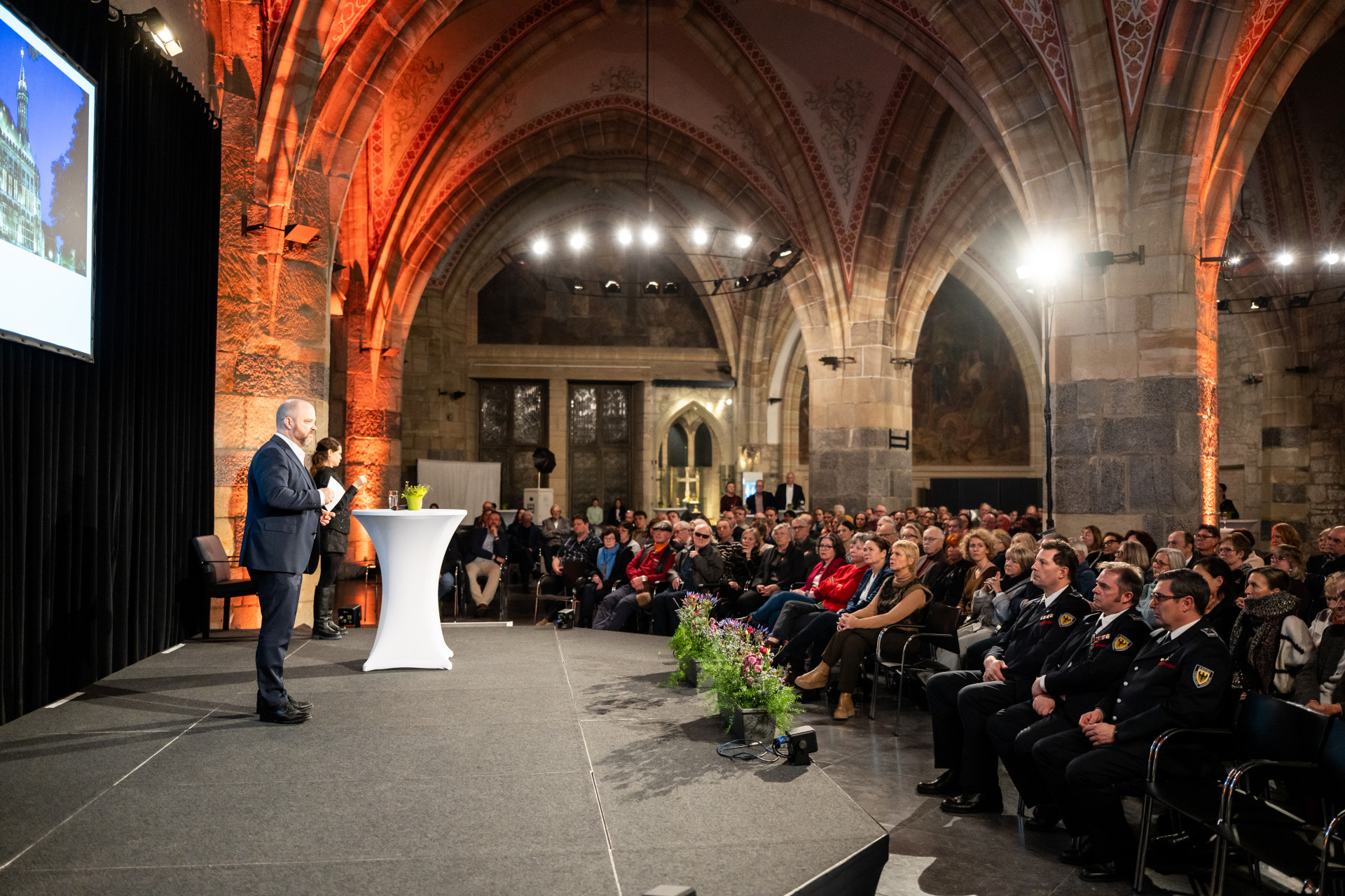 Der Oberbürgermeister steht auf einer Bühne vor Publikum im Krönungssaal.