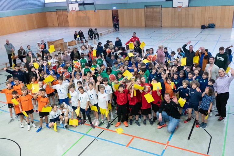 129 Kinder sitzen in der Sporthalle