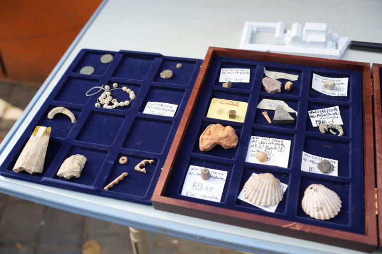 Muscheln, Perlen und Mosaiksteinchen in einer blauen Aufbewahrungsbox.