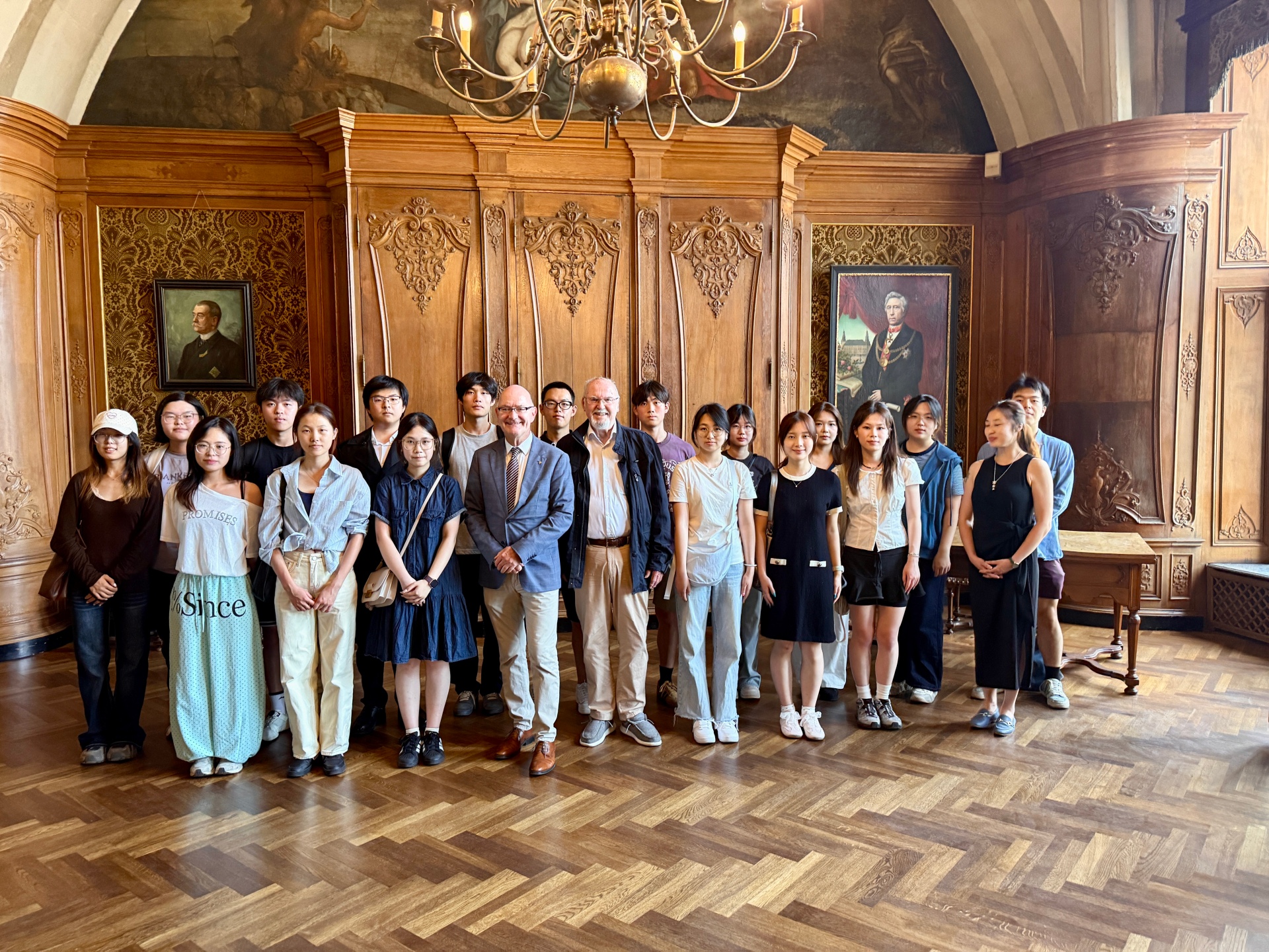 Eine Gruppe chinesischer Studierende stehen zusammen mit Dr. Ralf Otten und Udo Mathes, in einem Saal im Aachener Rathaus.