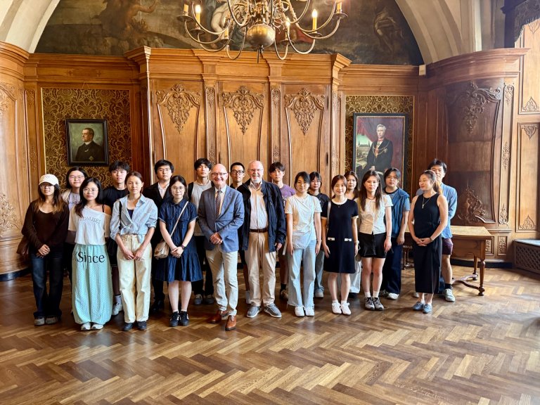 Eine Gruppe chinesischer Studierende stehen zusammen mit Dr. Ralf Otten und Udo Mathes, in einem Saal im Aachener Rathaus.