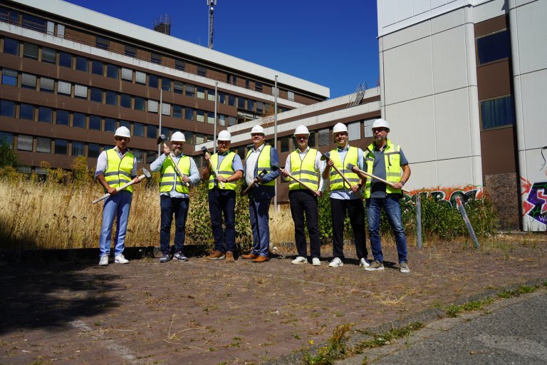 Gruppe mit Helmen vor einem Gebäude