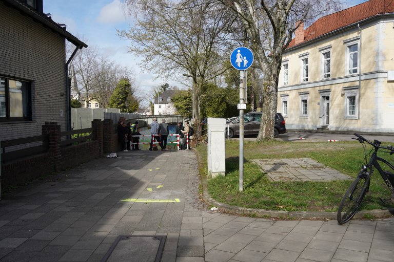 Ein blauweißes "Fußgängerweg"-Schild vor dem Abhang einer Unterführung.