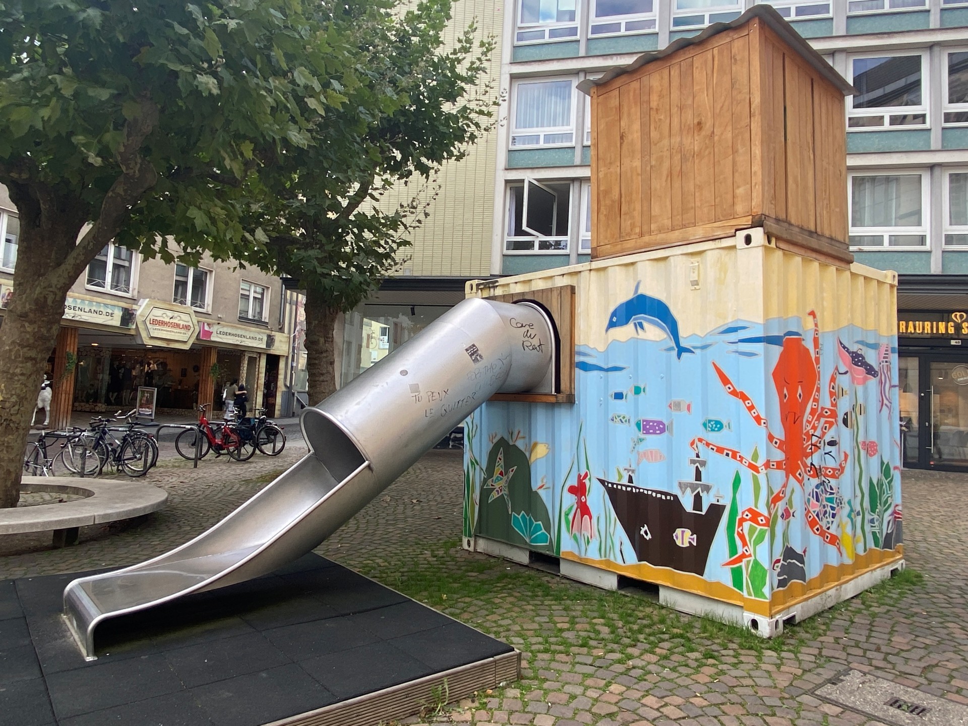 Ein buntbemalter Container mit einer Rutschbahn.