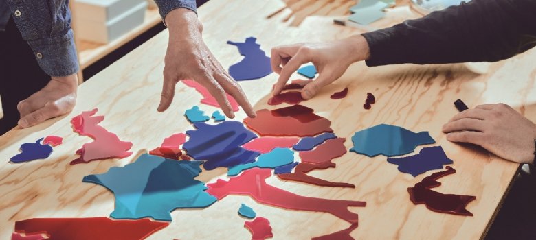 Europa Tischpuzzle Menschen puzzlen auf einem Tisch ein europäisches Puzzle